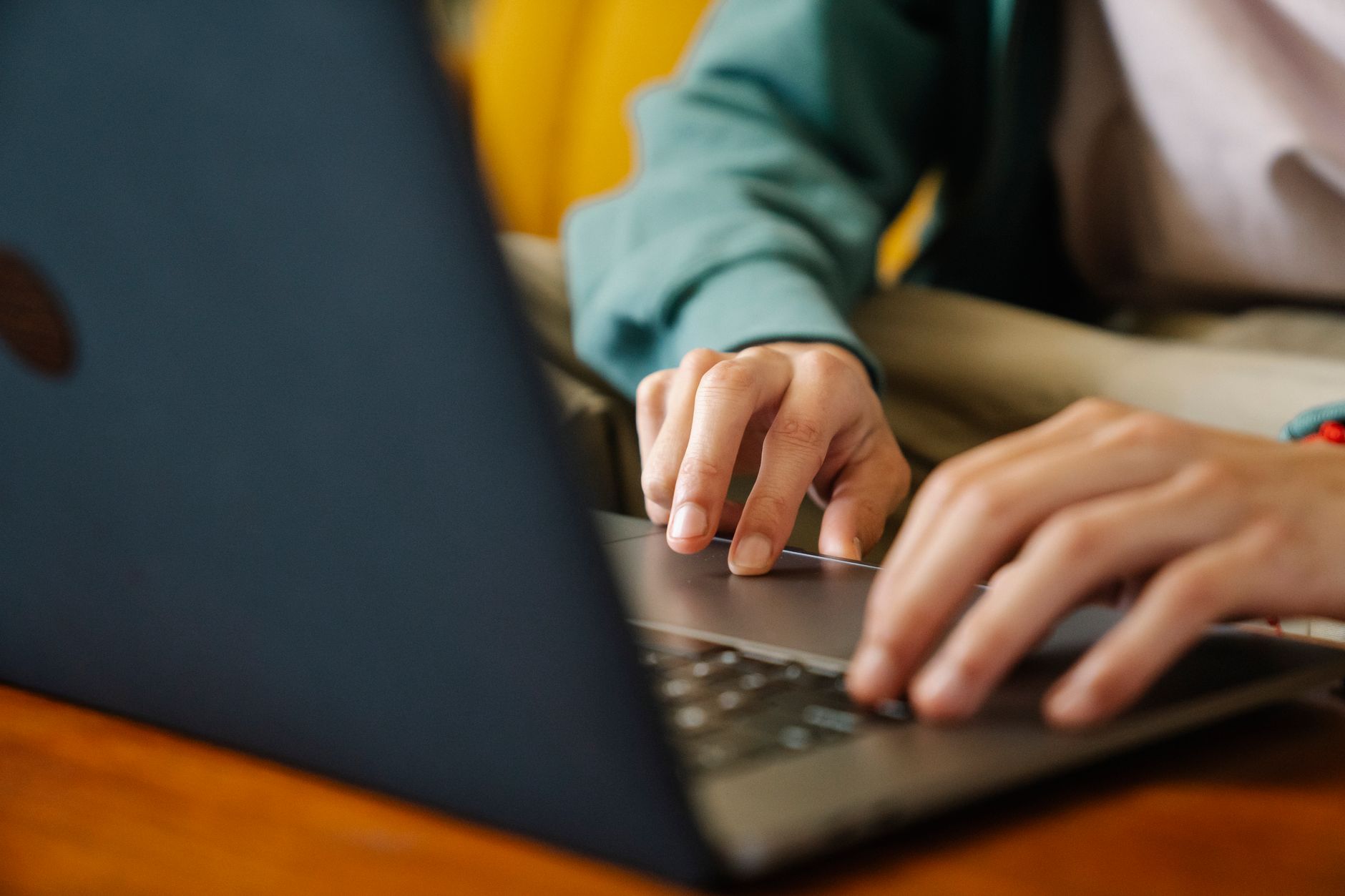 Persona trabajando en su portátil en un escritorio, navegando en internet mientras avanza en un proyecto.